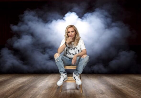 Patrycja Kosiarkiewicz siedzi na stołku na tle dymu